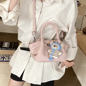 Pink textured leather bucket bag with cute bear charm and adjustable shoulder strap