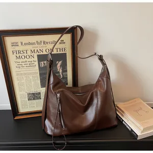 Détail du sac hobo marron vintage en similicuir lisse avec fermeture éclair latérale pratique