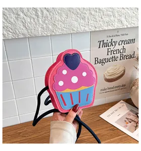 Detail of cute cupcake-shaped crossbody bag with pink and blue colors and heart decor