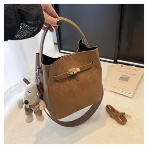 Detailansicht braune Beuteltasche aus Wildleder mit Goldschloss und Hunde-Anhänger