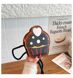 Detail view of a cupcake shaped cartoon crossbody bag with blue rope strap and PU leather
