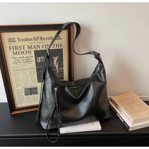 Détails du sac cabas minimaliste en cuir noir avec bandoulière réglable et ferrures