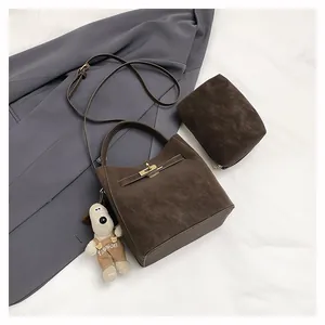 Detailansicht der dunkelbraunen Beuteltasche mit mattem Finish und kleinem Anhänger