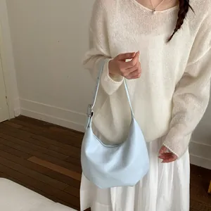 Detail of light blue crescent hobo bag with adjustable strap and silver metal buckle