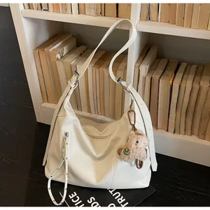 Détail du sac cabas minimaliste en similicuir beige avec un charme d'alpaga doux