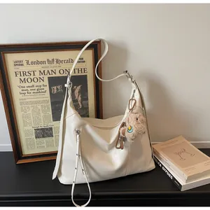 Détail du sac fourre-tout crème en cuir PU avec fermeture à franges et pendentif mouton