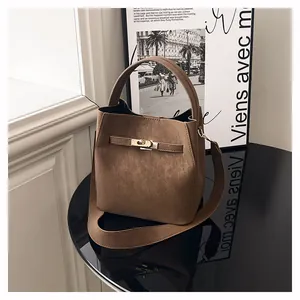 Nahaufnahme braune Wildleder-Eimertasche mit goldenem Metallverschluss und Schultergurt