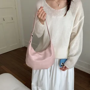 Detail shot of pale pink crescent hobo bag with adjustable strap and silver buckle