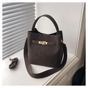 Detail der kaffeebraunen Beuteltasche mit matten Velours-Finish und Goldverschluss