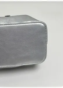 Detailed close-up of thickened base on metallic silver bucket bag with lychee texture