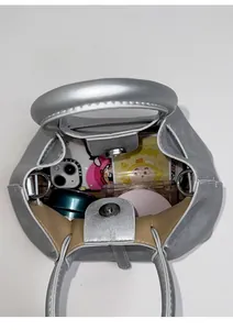 Detailed interior view of silver bucket bag showing magnetic closure and storage capacity