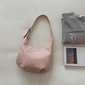 Detailed top view of a pink crescent shoulder bag with silver hardware and pleated base