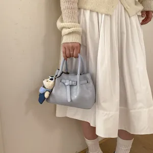 Light blue faux leather bucket bag with decorative belt strap and cute bear charm