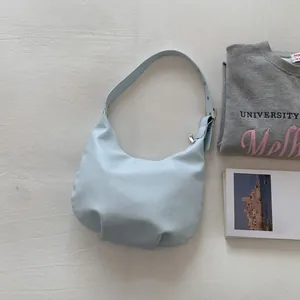 Detail of light blue leather crescent hobo bag with adjustable strap and silver metal buckle