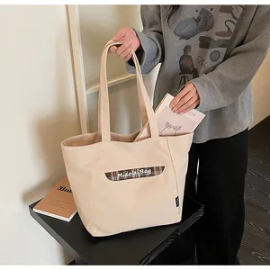 Dettaglio della borsa tote in tela beige con finiture a quadretti e logo MidolaiBag