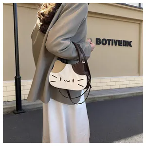 Close-up of cute cat-shaped crossbody bag with tricolor patchwork and embroidered details