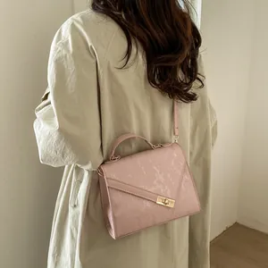 Pink crossbody bag with vertical texture shown on model in beige trench coat