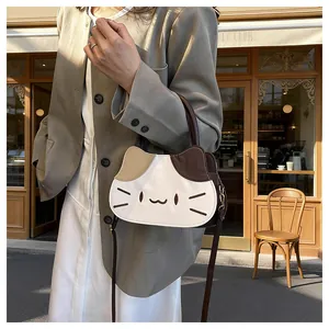 Detail of color-block kitten handbag with cat face embroidery and brown shoulder strap