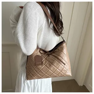 Detail showing brown quilted tote bag texture with a cute bow and fashion hangtag