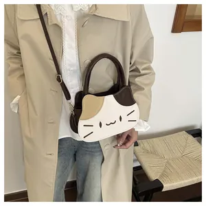 Detail of cute cat-shaped crossbody bag with gold hardware and contrast stitching