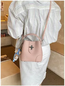Detailed shot of a pink bucket bag with litchi texture and a cute bear charm