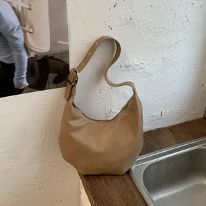 Detail of khaki crescent hobo bag featuring matte faux leather and silver metal buckle