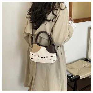 Rear view of a cute tricolor cat-shaped crossbody bag with gold metal buckle on a trench coat
