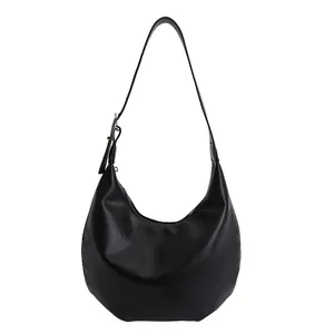 Minimalist black crescent hobo shoulder bag with adjustable strap on white background