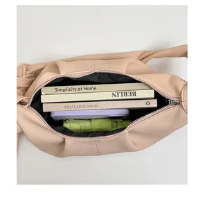 Makroaufnahme des geräumigen Innenraums der rosa Schultertasche mit Falten-Design