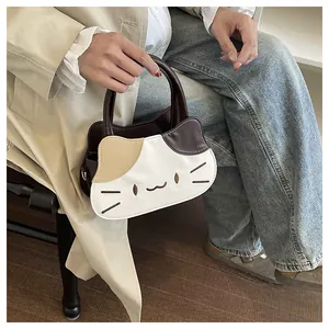 Detail of cartoon cat-shaped handbag featuring contrast stitching and embroidery