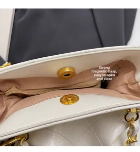 Detail of the strong magnetic buckle and inner lining on a white quilted bucket bag