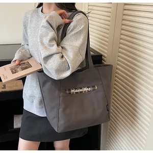 Dettaglio della borsa tote in tela grigio scuro con cuciture scozzesi e logo Midolai