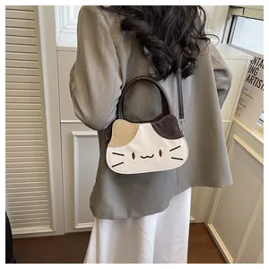 Rear view of a model wearing a cat-shaped crossbody bag with contrast stitching