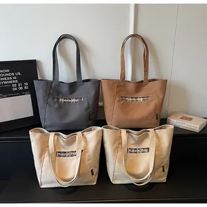 Dettaglio di grandi borse tote in tela con strisce a quadretti e manici eleganti