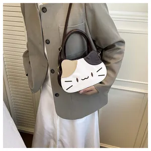 Detail view of cat-shaped crossbody bag with contrast stitching and embroidery