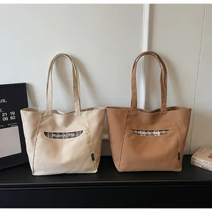 Dettaglio delle borse tote in tela con cuciture a contrasto e testo Midolai in stile casual