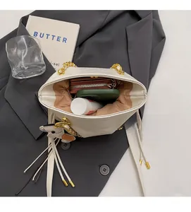 Top view of white quilted bucket bag showing spacious interior for phone and wallet