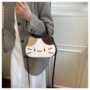 Detail of a cat-shaped crossbody bag featuring tricolor patchwork and embroidered kitten face