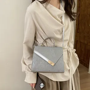 Grey textured crossbody handbag for women with metallic lock and shoulder strap