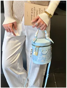 Dettaglio borsa a secchiello celeste con manico in foulard di seta e tracolla regolabile
