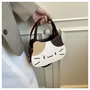 Detail of the cat-shaped handbag showing its color-block design and embroidered whiskers