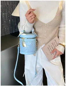 Detail of light blue lace bucket bag featuring floral scarf handle and gold hardware
