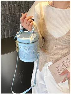 Dettaglio borsa a secchiello azzurra con pizzo floreale e foulard decorativo in seta moda