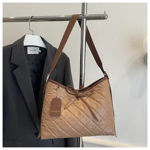 Detail of dark brown quilted leather bag with elegant stitching and fashion hangtag