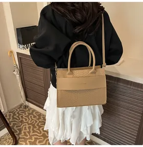 Dettaglio borsa beige con trama a serpente con manici e tracolla sottile regolabile