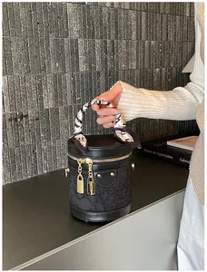 Dettaglio della borsa a secchiello nera con pizzo, lucchetto dorato e foulard di seta
