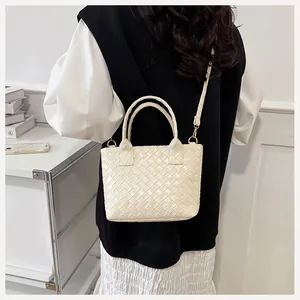 Close-up of woven bucket bag texture with sturdy round handles and creamy white finish
