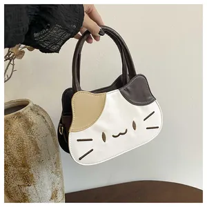 Detail shot of the cute cat-shaped handbag featuring contrast color stitching and cat face embroidery