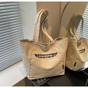 Dettaglio della borsa tote in tela con tasca a quadri marroni e trama in tessuto fine