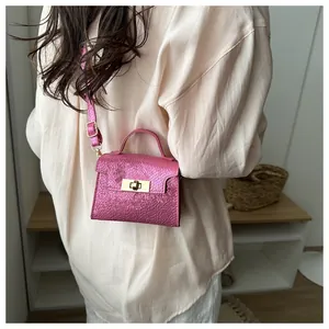 Metallic pink snake texture mini crossbody bag with gold lock shown on model